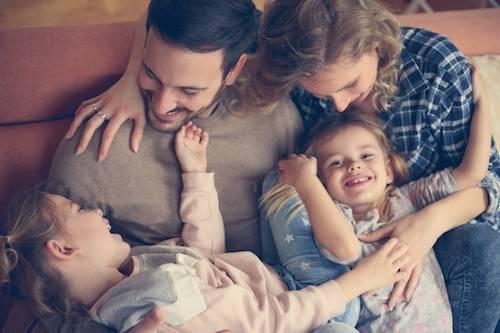 Family of four playing on the couch after dental Cleanings in Decatur, IL