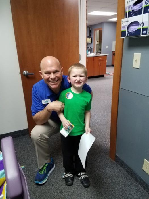 Dentist pose with a kid after dental treatment at Jerger Pediatric Dentistry