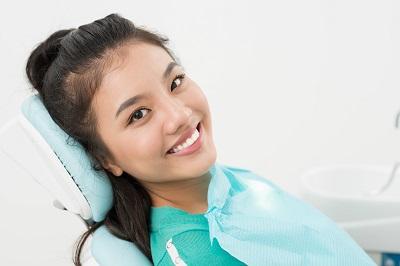 woman smiling in dental exam chair l orthodonics decatur il