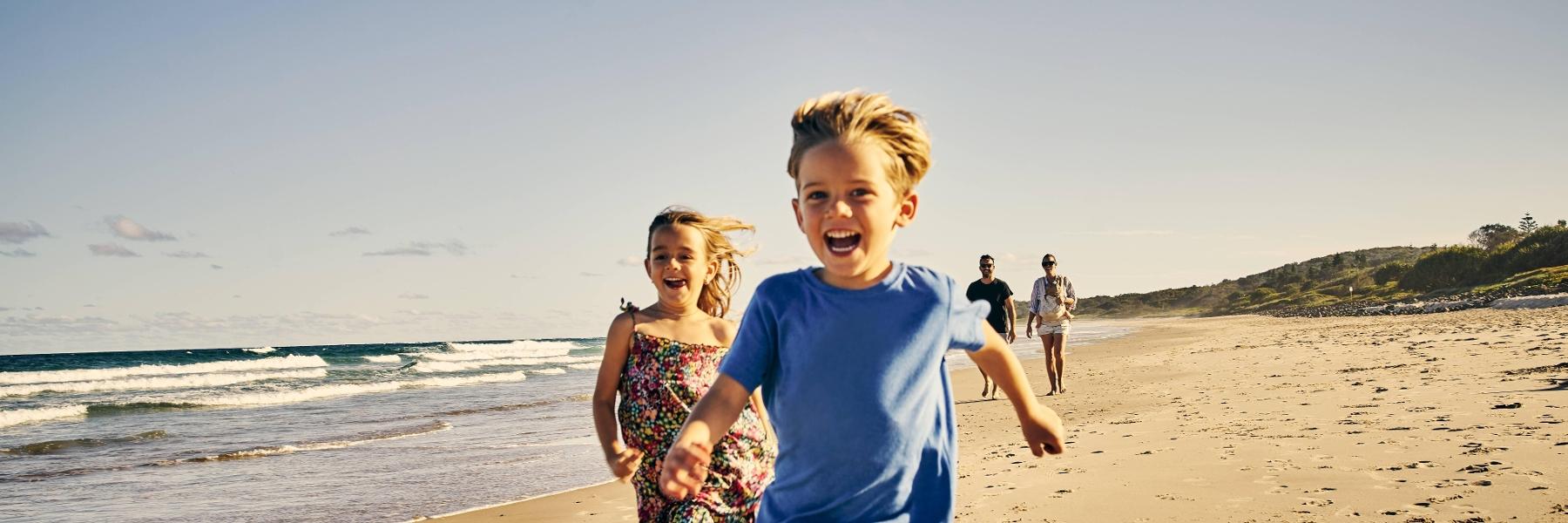 Young boy running on beach after dentistry session in Decatur, IL