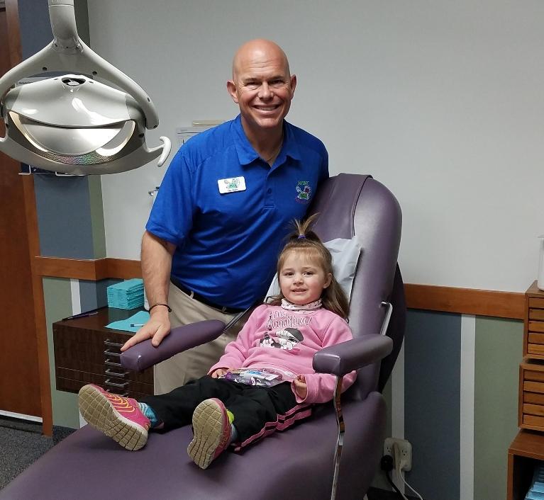 Dentist pose with a kid after dental treatment at Jerger Pediatric Dentistry