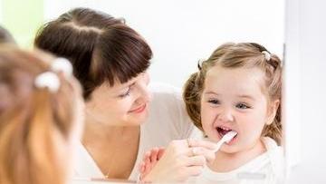 Mother brushing her daughters teeth in Decatur, IL