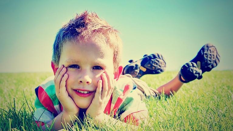 Kid lying on the grass during Coats For Kids Community Event Decatur IL