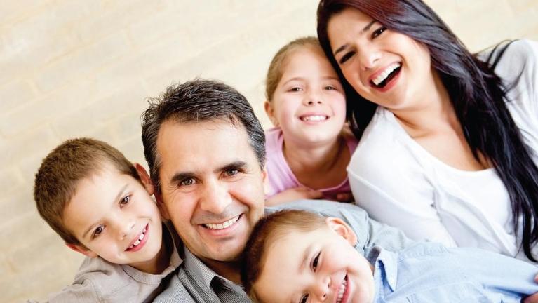 Family of five smiling after dental check up in Decatur, IL