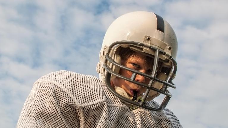 kid with football helmet playing after visiting Jerger Pediatric Dentistry