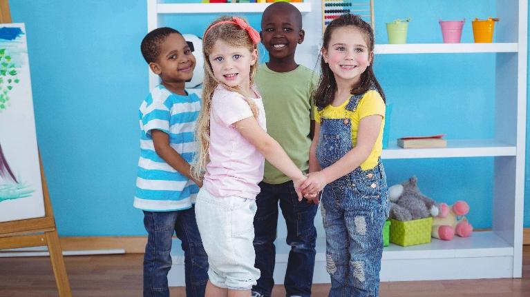 Four children holding hands in circle after dental treatment at Jerger Pediatric Dentistry