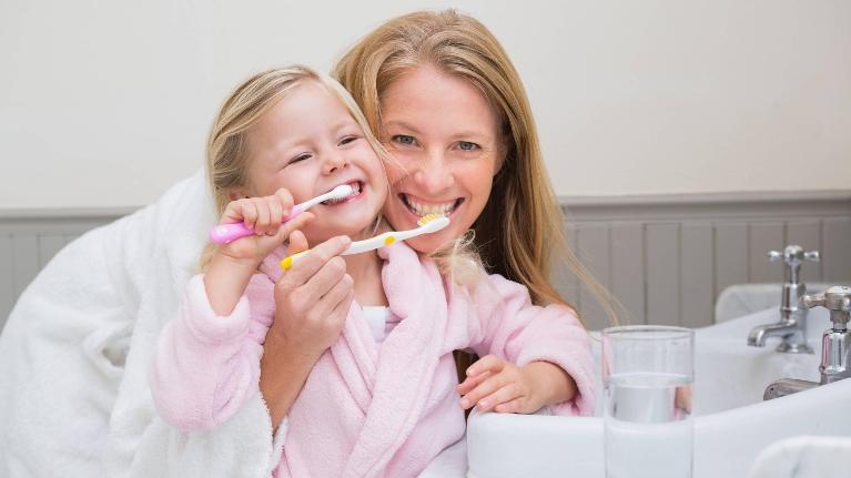 Mother and kid brushing their teeth in Decatur, IL