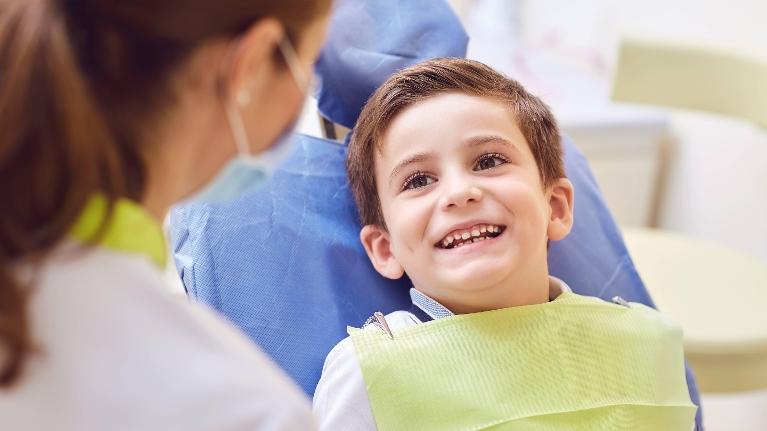 Young boy smiling during dental examination in Decatur, IL