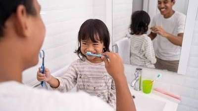 Parent helping the kid brush teeth in Decatur, IL