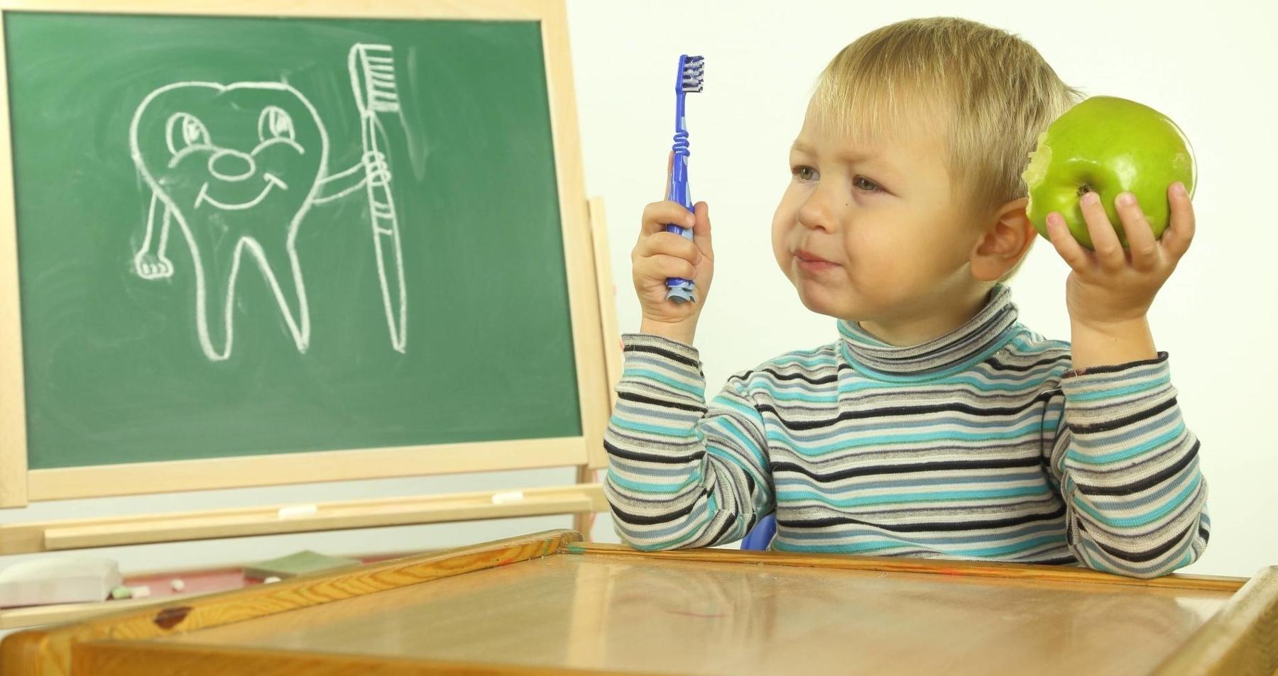 Young boy with toothbrush and apple l Dentist Decatur IL